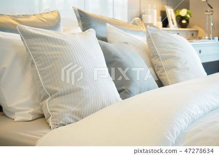 Closeup roll of pillows setting on comfortable bed Closeup roll of pillows setting on comfortable bed 47278634