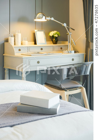 Books on bed with working table in background Books on bed with working table in background 47278635