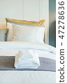 Clean white towels setting on bed in bedroom 47278636