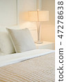 Beige pillow on comfy bed in modern bedroom 47278638