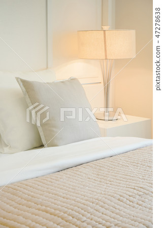 Beige pillow on comfy bed in modern bedroom 47278638