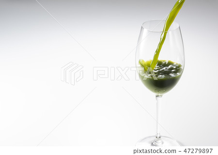 Pour the green juice into the glass 47279897