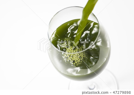 Pouring green juice into a glass 47279898