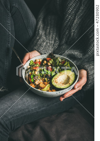 Woman holding bowl with fresh salad, avocado 47280902