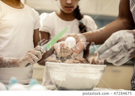 Close up of daughters and father having their hands in flour 47284675