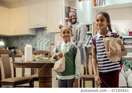 Two funny stylish daughters feeling excited while leaving to school Two funny stylish daughters feeling excited while leaving to school 47284881