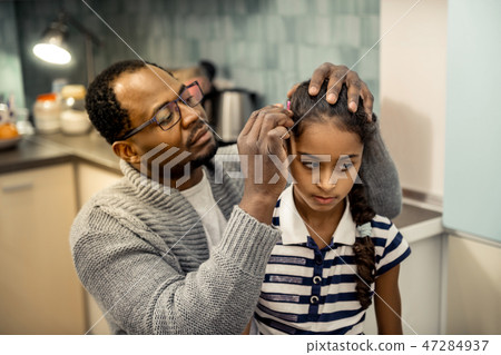 Father wearing grey cardigan fixing hairstyle of his daughter Father wearing grey cardigan fixing hairstyle of his daughter 47284937