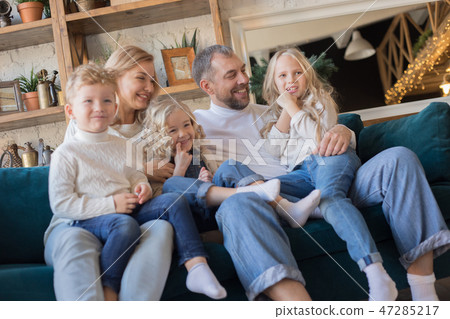 Happy family is sitting on the sofa and having fun. 47285217