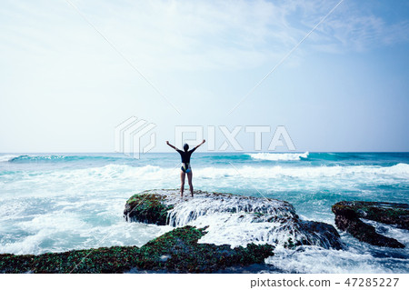 Cheering woman outstretched arms at seaside Cheering woman outstretched arms at seaside 47285227