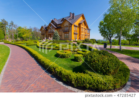 a path from tiles enveloping a flower bed with a d 47285427