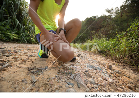 Asian woman runner hold her sports injured leg   47286216