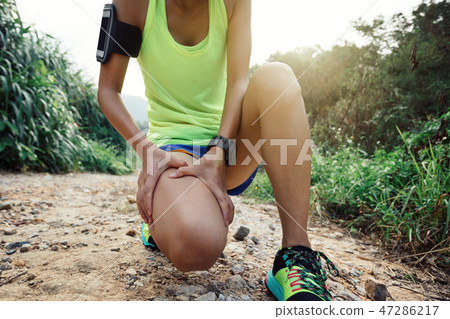 Asian woman runner hold her sports injured leg   47286217