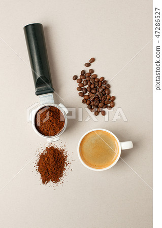 Cup of black coffee next to coffee beans and grain Cup of black coffee next to coffee beans and grain 47286527