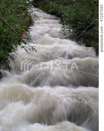 River Garw in full flood tumbling down hillside framed by overhanging trees, Blaengarw, South Wales River Garw in full flood tumbling down hillside framed by overhanging trees, Blaengarw, South Wales 47287085