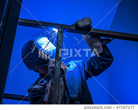 Welder Worker Performs Jump Welding. Worker Welder Performs Arc-Welding Process of Metal Structures 47287277