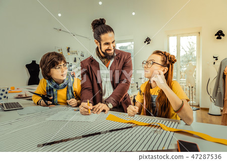 Father working as fashion designer teaching his children Father working as fashion designer teaching his children 47287536