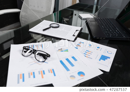 Financial documents with magnifying glass and insurance lie on black table in office close-up Financial documents with magnifying glass and insurance lie on black table in office close-up 47287537