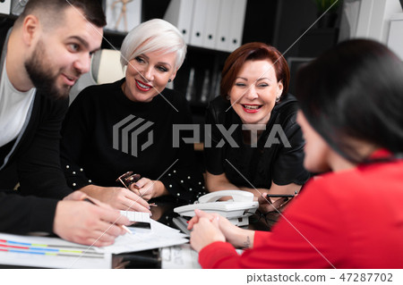 Smiling employees talking in workplace 47287702