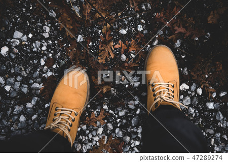 Feet of traveler in yellow boots standing on Feet of traveler in yellow boots standing on 47289274