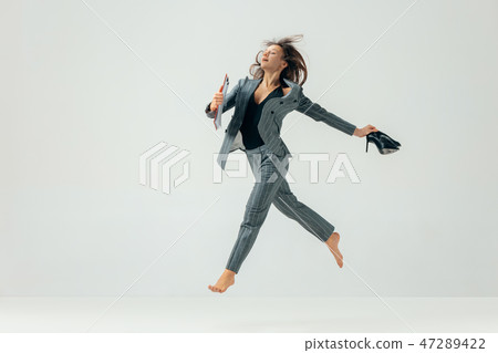 Happy business woman dancing and smiling isolated over white. 47289422