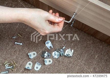 Installation of furniture using allen key, closeup 47289475