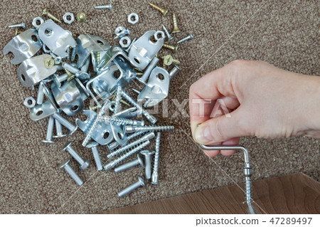 close-up hand turning hex wrench in diy furniture. close-up hand turning hex wrench in diy furniture. 47289497
