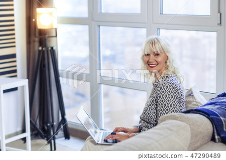 Joyful nice woman enjoying her time at home Joyful nice woman enjoying her time at home 47290489