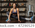 Young happy fitness woman doing leg stretching exercise 47290529