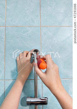 close-up hands tighten screw holder for shower close-up hands tighten screw holder for shower 47291086