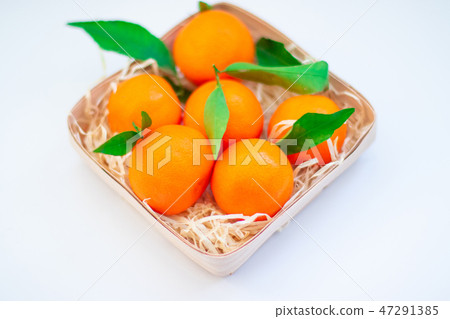 Tangerines with green leaves in a basket  47291385