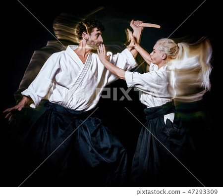 Aikido budokas man and woman isolated black background Aikido budokas man and woman isolated black background 47293309