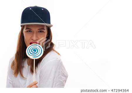 Woman holding biting a lollipop in hip-hop cap Woman holding biting a lollipop in hip-hop cap 47294364