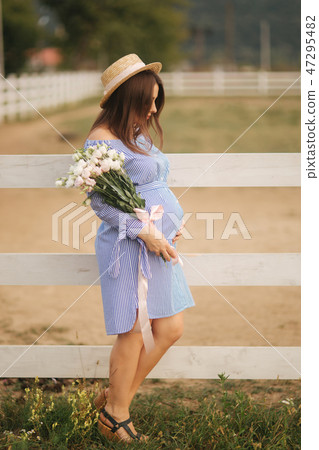Georgeus woman stand in front of farm and hold a bouquet of flower in hands. Beautuful bouquet Georgeus woman stand in front of farm and hold a bouquet of flower in hands. Beautuful bouquet 47295482