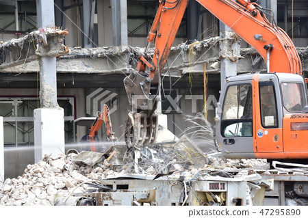 A hydraulic excavator equipped with a grapple performing sorting work at a demolition site 47295890
