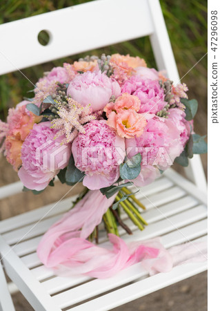 wedding bouquet of pink peonies tied with ribbons 47296098