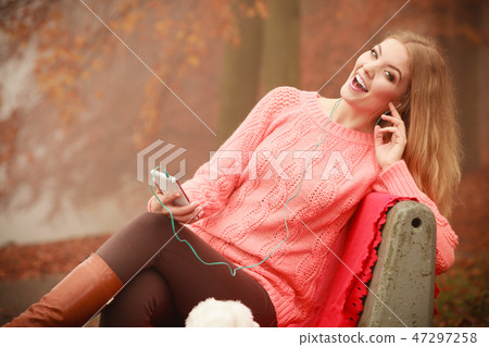 girl listening to music in autumn park girl listening to music in autumn park 47297258