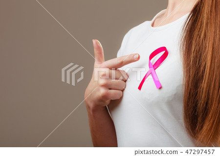 Pink ribbon on woman chest to support breast cancer cause 47297457