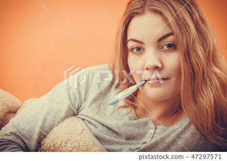 Sick ill woman with digital thermometer in mouth. Sick ill woman with digital thermometer in mouth. 47297571