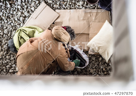 A top view of homeless beggar man with belongings outdoors in city. A top view of homeless beggar man with belongings outdoors in city. 47297870