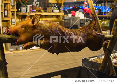 whole grilled pig on a spit in a restaurant whole grilled pig on a spit in a restaurant 47298252