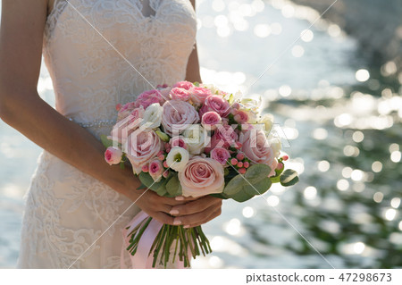 bride holds in hand a pink and white wedding bouquet on the background of the sea bride holds in hand a pink and white wedding bouquet on the background of the sea 47298673