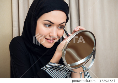 smiling young woman wearing makeup and hijab 47298721