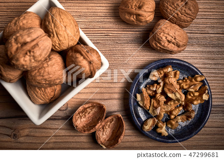 group of tasty nuts next to a bowl group of tasty nuts next to a bowl 47299681