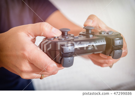 Woman plays video game using the gamepad 47299886