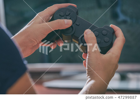 Woman plays video game using the gamepad Woman plays video game using the gamepad 47299887