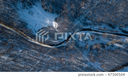 Curvy windy road in snow covered forest, top down aerial view. Curvy windy road in snow covered forest, top down aerial view. 47300504