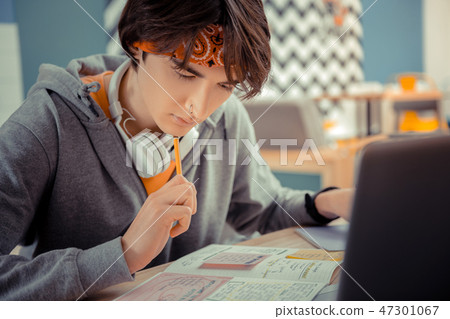 Concentrated student thinking on his difficult hometask Concentrated student thinking on his difficult hometask 47301067