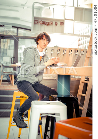 Teenager sitting in the cafe with a cup of coffee Teenager sitting in the cafe with a cup of coffee 47301084