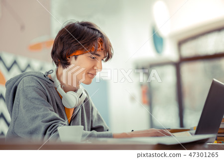 Teenager working with the computer while sitting in the cafe 47301265