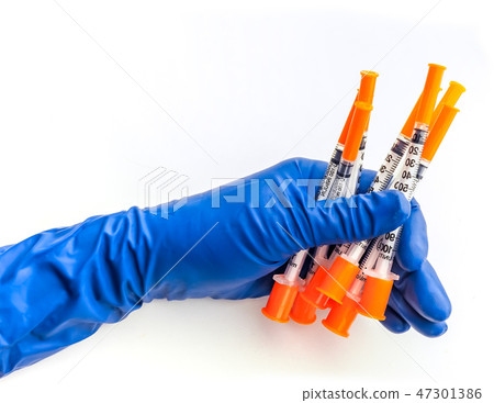 Doctor's hand in blue medical glove holding several syringes with medical solution white isolated Doctor's hand in blue medical glove holding several syringes with medical solution white isolated 47301386